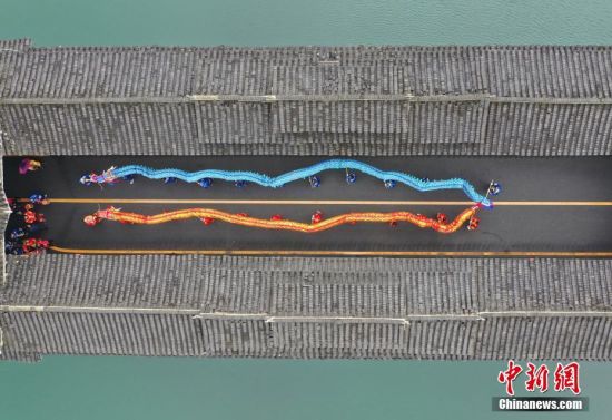 2月19日，民间艺人在贵州省铜仁市玉屏侗族自治县风雨桥上进行舞龙表演，欢庆元宵佳节。中新社发 胡攀学 摄