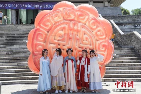 9月13日，市民穿着汉服在月饼模型前合影。当日，贵州贵阳孔学堂举办“月映万家・中秋游园”中秋节传统文化活动，吸引众多市民参与，感受中秋文化。中新社记者 瞿宏伦 摄