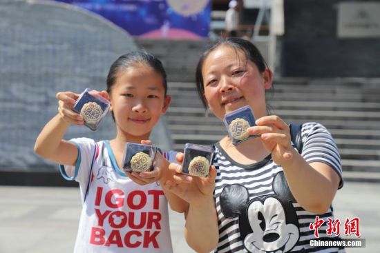 9月13日，一对母女展示亲手制作的月饼。当日，贵州贵阳孔学堂举办“月映万家・中秋游园”中秋节传统文化活动，吸引众多市民参与，感受中秋文化。中新社记者 瞿宏伦 摄