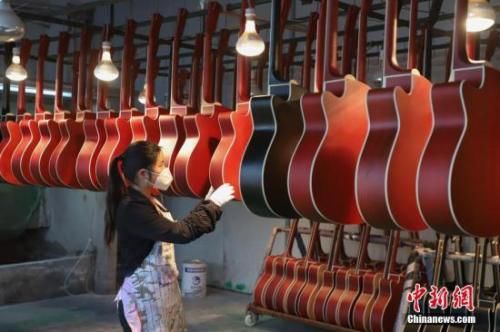 资料图为工人在整理喷漆后的吉他。中新社记者 瞿宏伦 摄